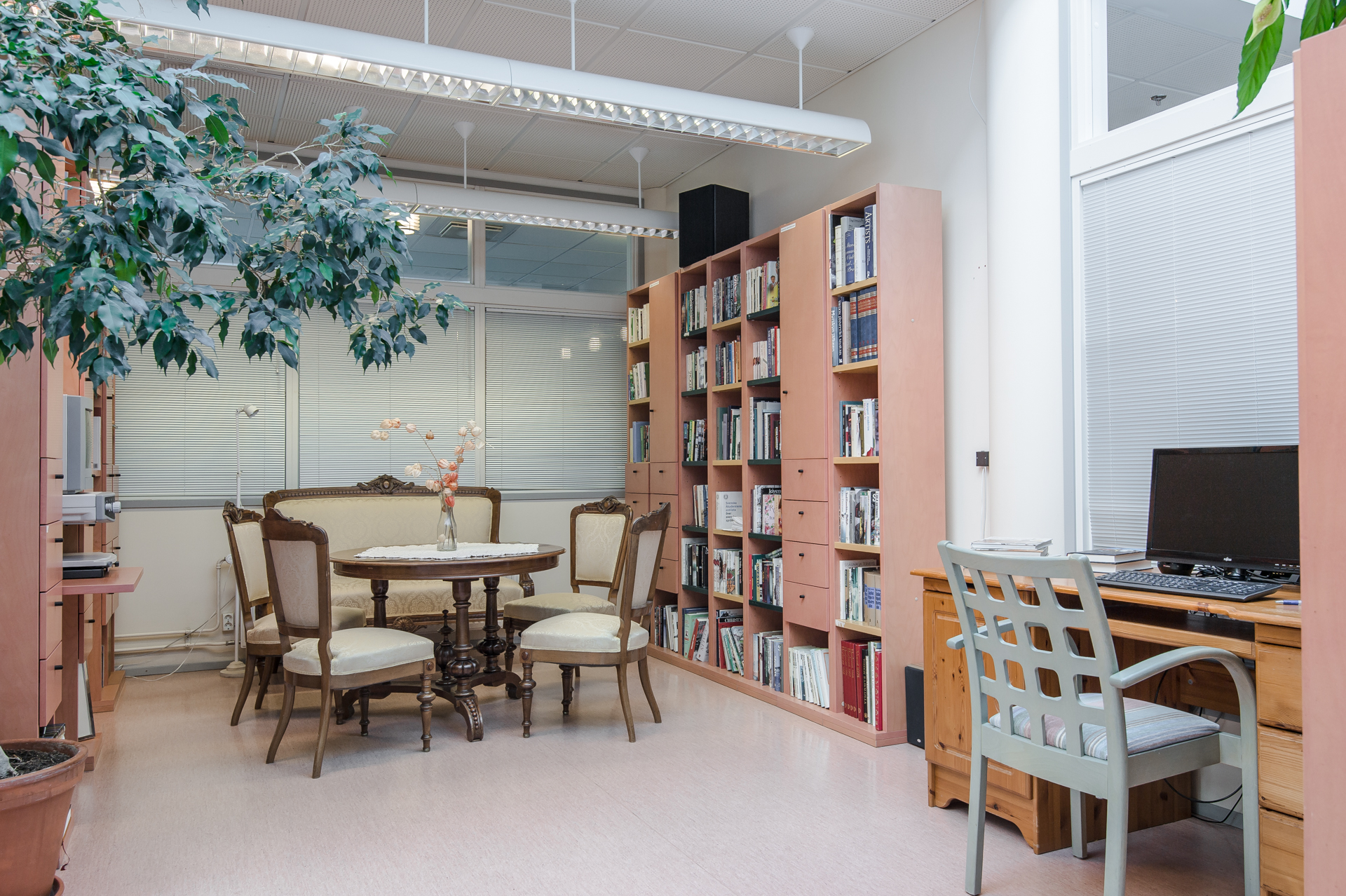 Ett rum med bokhyllor och sittplatser